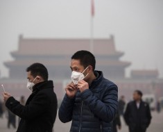 BEIJING, CHINA - DECEMBER 09: A  tourist puts on a face mask to protect against pollution as he visits Tiananmen Square during smog in Tiananmen Square on December 9, 2015 in Beijing, China. The Beijing government issued a "red alert" Sunday for the first time since new standards were introduced earlier this year as the city and many parts of northern China were shrouded in heavy pollution. Levels of PM 2.5, considered the most hazardous, crossed 400 units in Beijing, lower then last week, but still nearly 20 times the acceptable standard set by the World Health Organization. The governments of more than 190 countries are meeting in Paris to set targets on reducing carbon emissions in an attempt to forge a new global agreement on climate change.  (Photo by Kevin Frayer/Getty Images)
