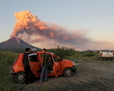 People look at the Momotombo volcano erupting in Papalonal community in La Paz Centro, Leon, Nicaragua on December 2, 2015. A large volcano in western Nicaragua, Momotombo, on Tuesday belched ash and gas up to a kilometer (3,000 feet) in the sky, sparking fears that the giant could be waking from a fitful 110-year-old slumber. AFP PHOTO/ STR / AFP / STR        (Photo credit should read STR/AFP/Getty Images)